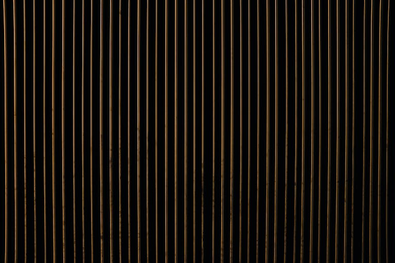 Aajkitajikhabar .com A close-up view of an abstract pattern with vertical gold and black stripes, creating a textured design.