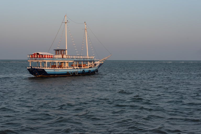 juntos seguros A serene sailing boat glides on the ocean at sunset near Porto Seguro, Brazil.