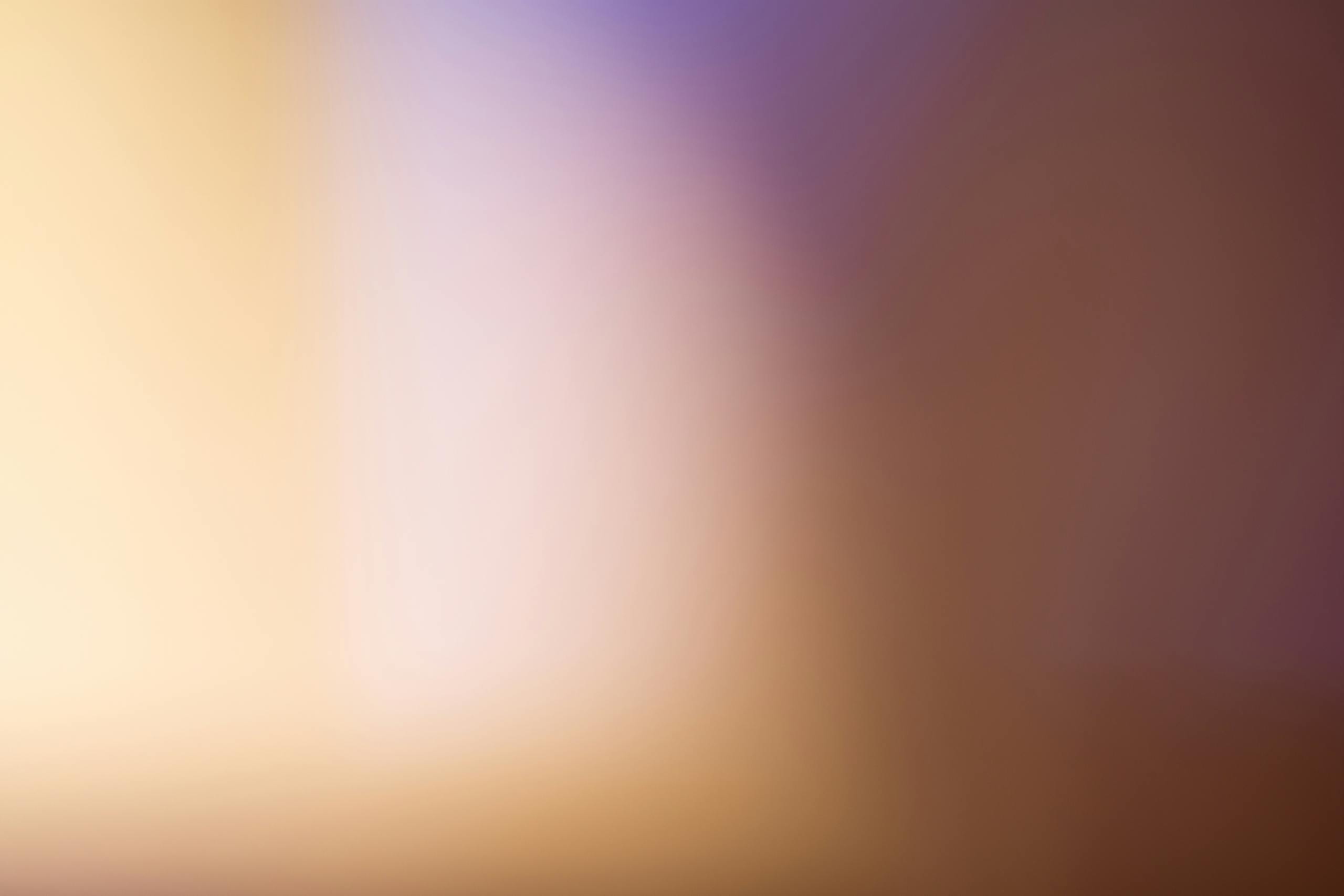 permanentad A soothing abstract blurred gradient background with warm tones.