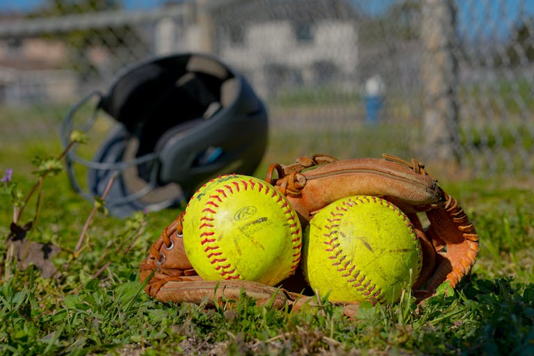 Miami Dolphins vs Houston Texans Close-up of baseball gear including balls, glove, and helmet on a field in Houston, TX.