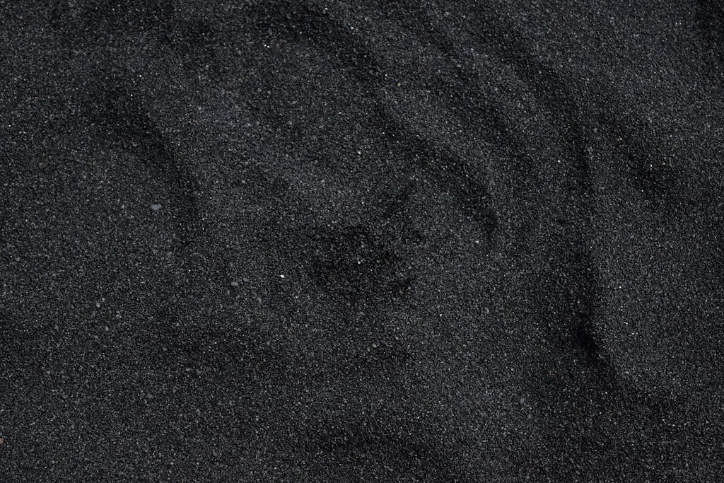 FamousParentingMomLife Close-up of black sand texture from Waimea Beach in Hawaii. Ideal for backgrounds.