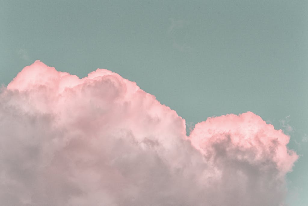 ventsMagazine Pastel pink clouds in a clear blue sky create a serene and dreamy atmosphere.