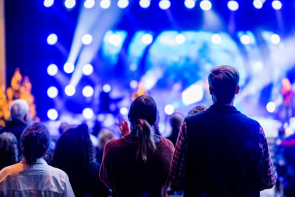 Wynonna Judd Performance Reactions Vibrant audience enjoying a live concert with colorful stage lights and performers.