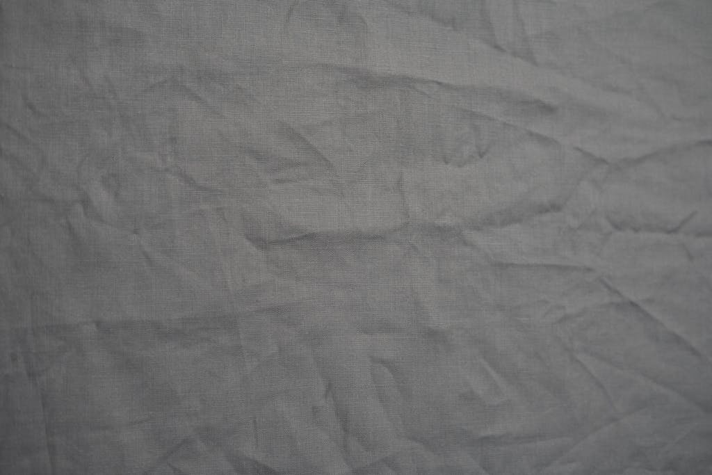  Mansutfer Wrinkled gray fabric texture ideal for backgrounds and creative projects.