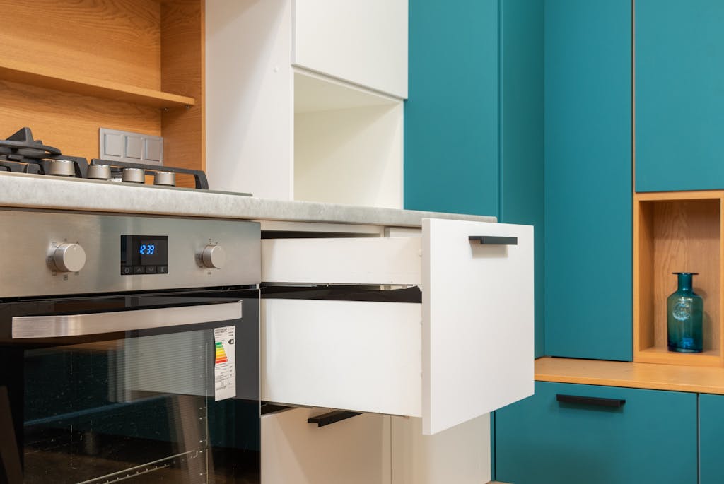 Memorandum to Cabinet Contemporary kitchen interior showcasing a stainless steel oven and teal cabinetry.