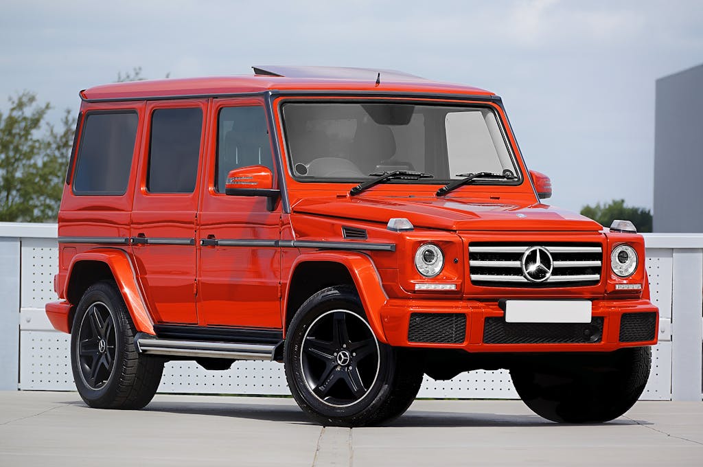unbanned g+ Striking red Mercedes-Benz SUV captured in a modern outdoor setting.
