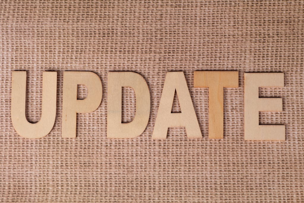 rajkot updates news Wooden letters arranged to spell 'UPDATE' on a textured burlap surface, perfect for business or project imagery.